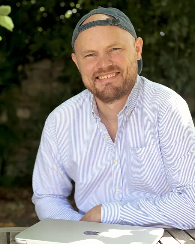 Max Hartung, Gründer von ElefantEins, lachend am Schreibtisch